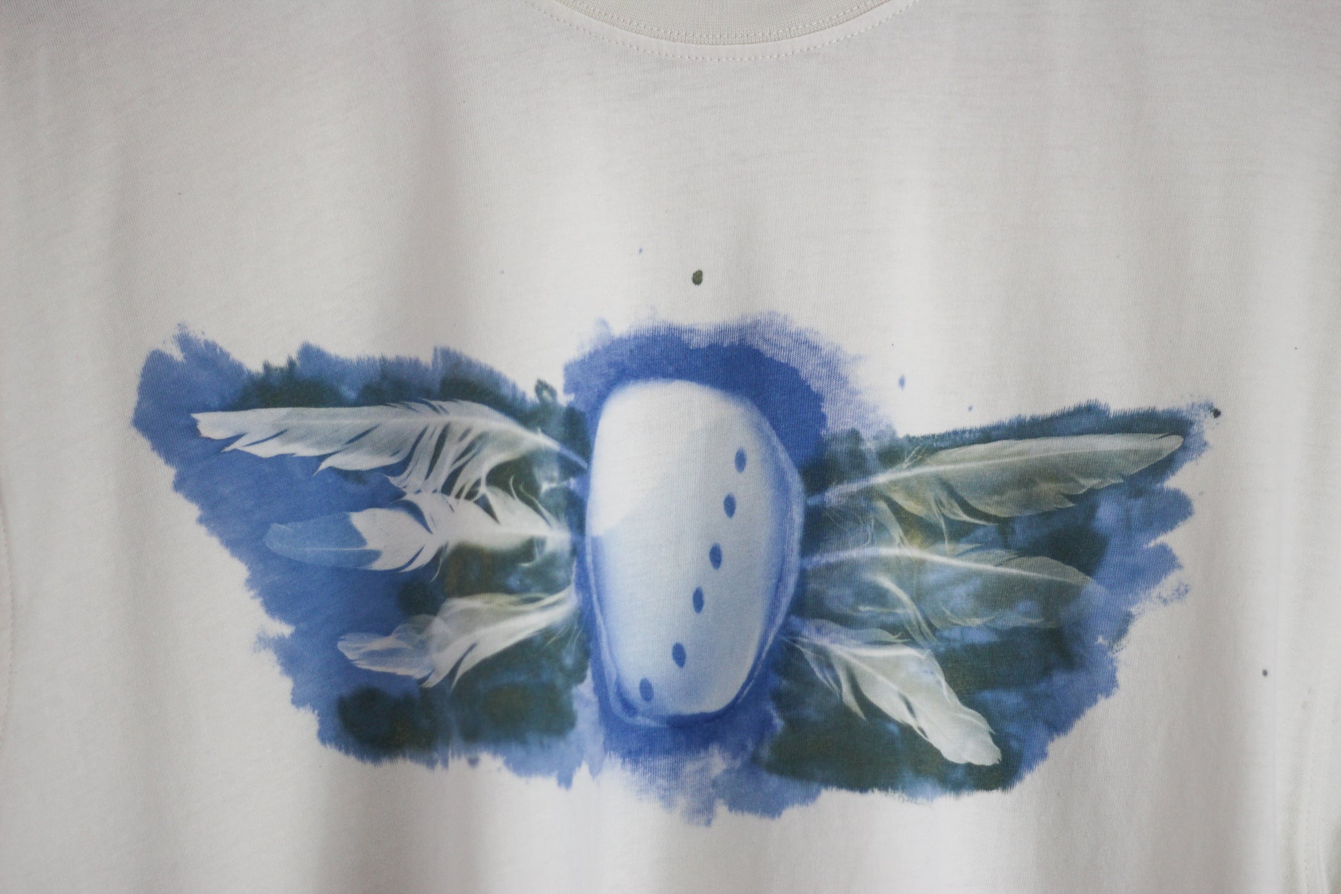 Hand-printed abalone shell and feather design graphic t-shirt.