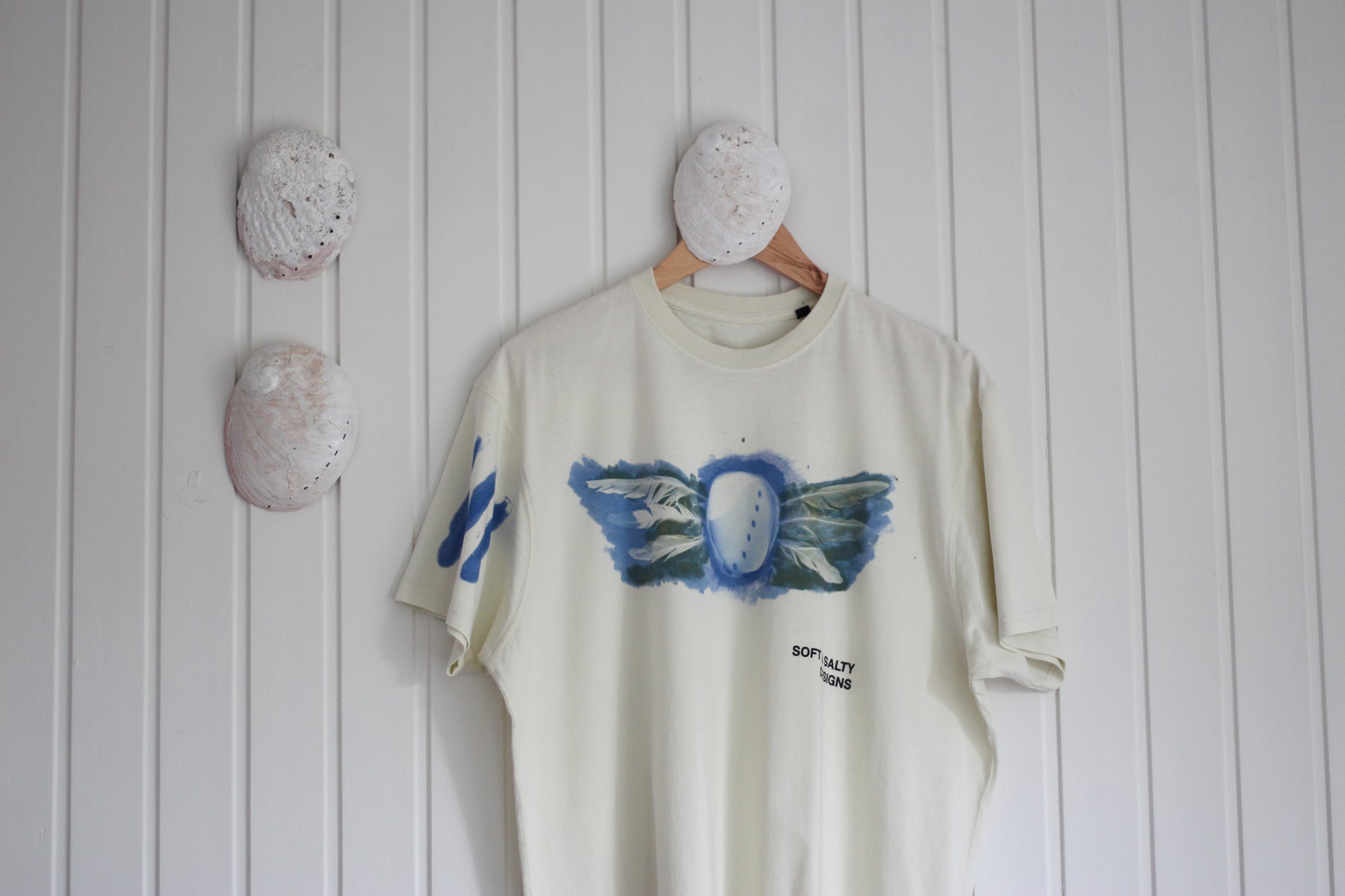 Hand-printed abalone shell and feather design graphic t-shirt.