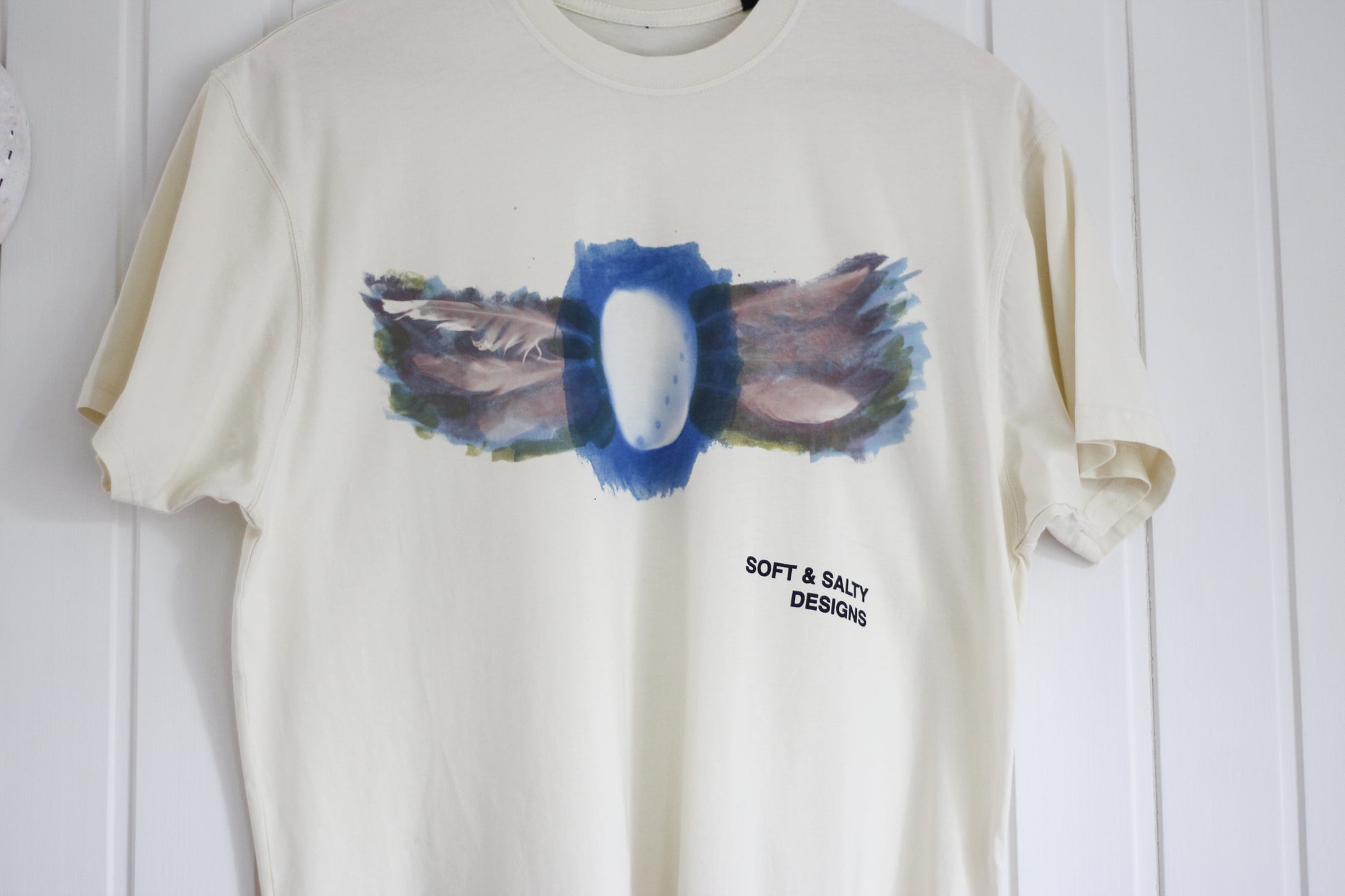 Hand-printed abalone shell and feather design graphic t-shirt.
