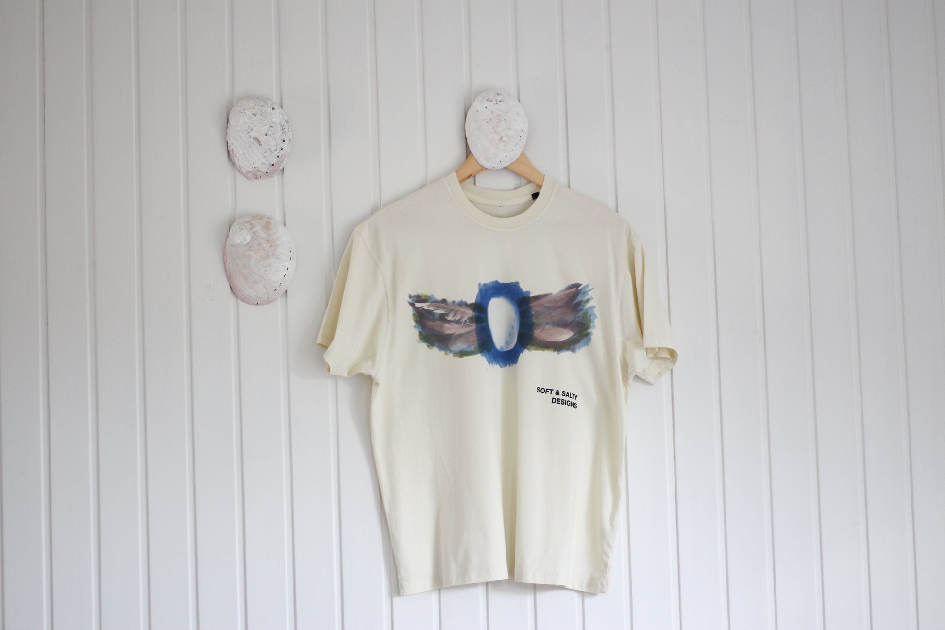 Hand-printed abalone shell and feather design graphic t-shirt.