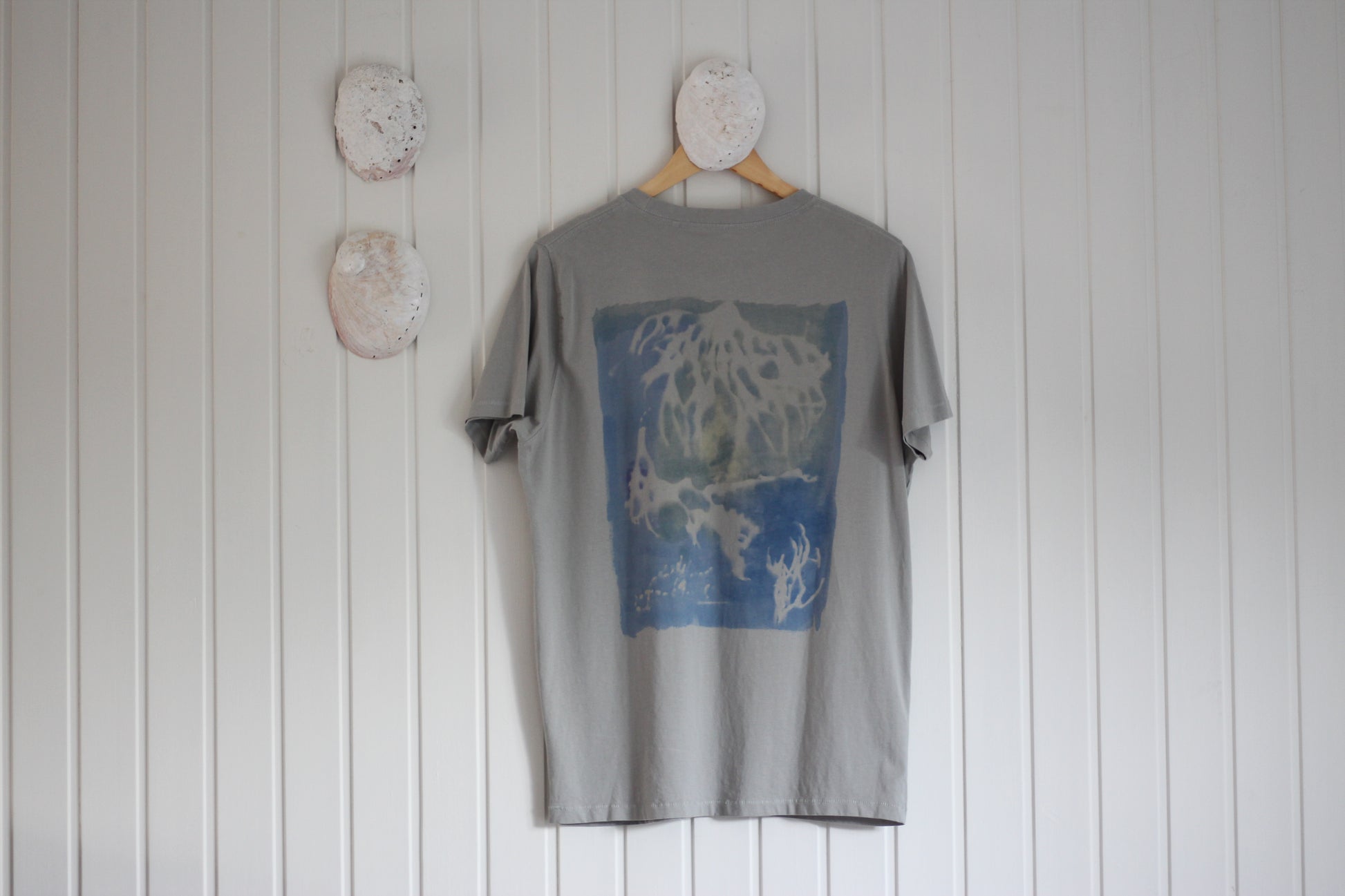 Graphic t-shirt with blue and green ocean-inspired sea sponge design, hand painted.
