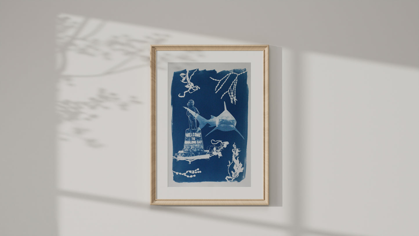A framed art print featuring a blue and white ink-style illustration of a shark and marine elements, displayed on a light gray wall with soft shadow overlays.