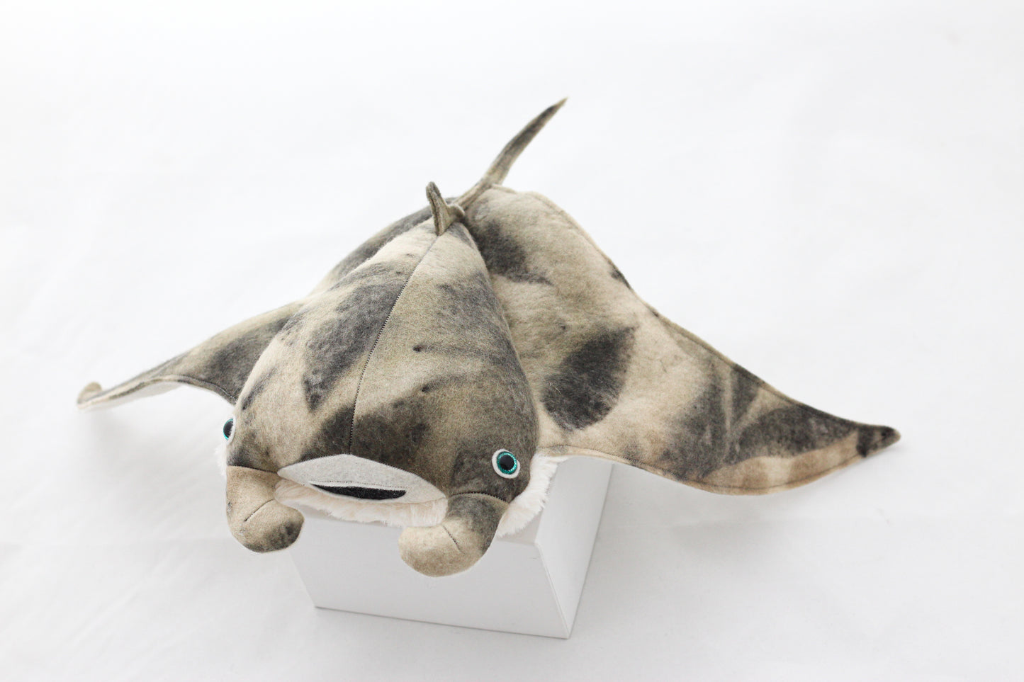 Plush toy manta ray with a white background