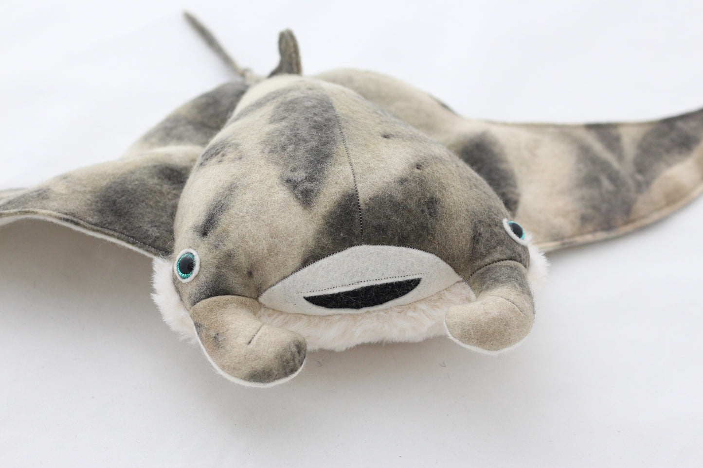 Plush toy manta ray with a white background