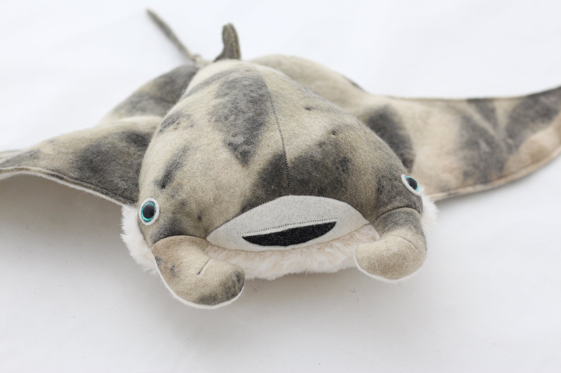 Plush toy manta ray with a white background