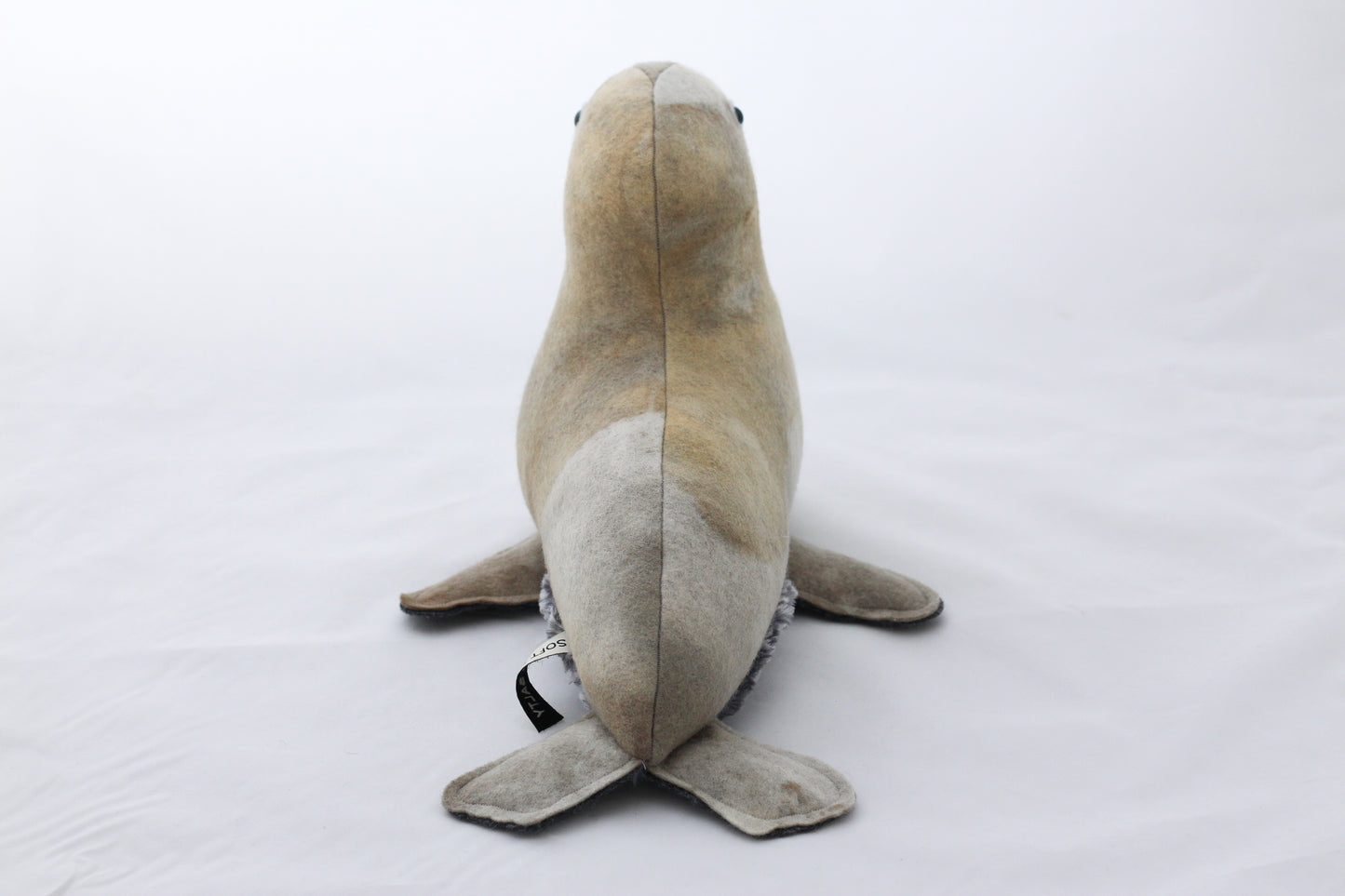 Hand dyed plush toy seal on a white background