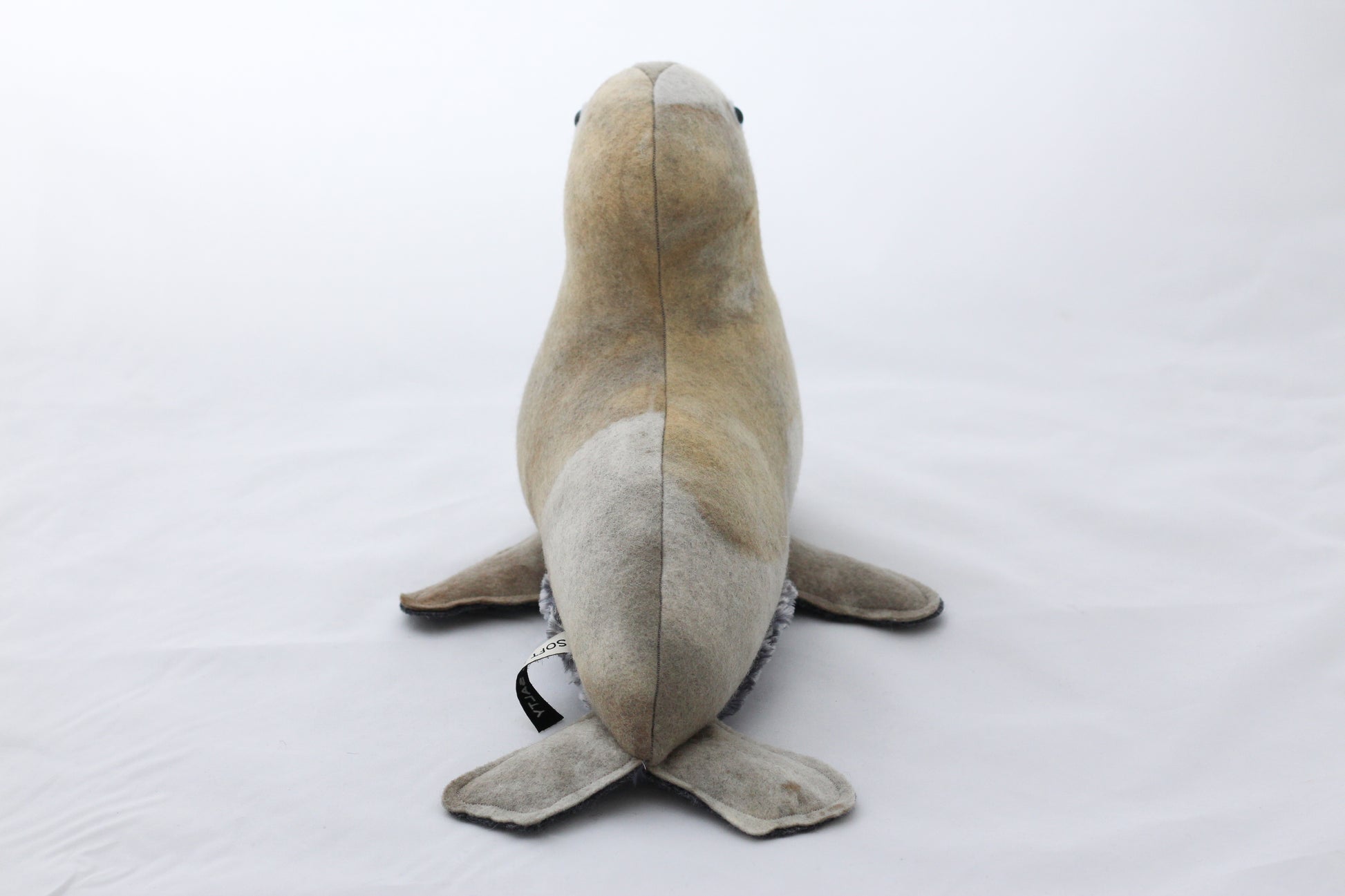 Hand dyed plush toy seal on a white background