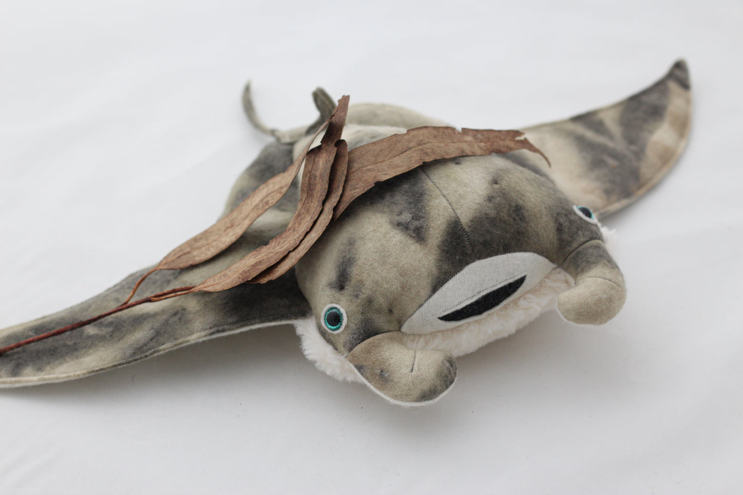 Plush toy manta ray with a white background