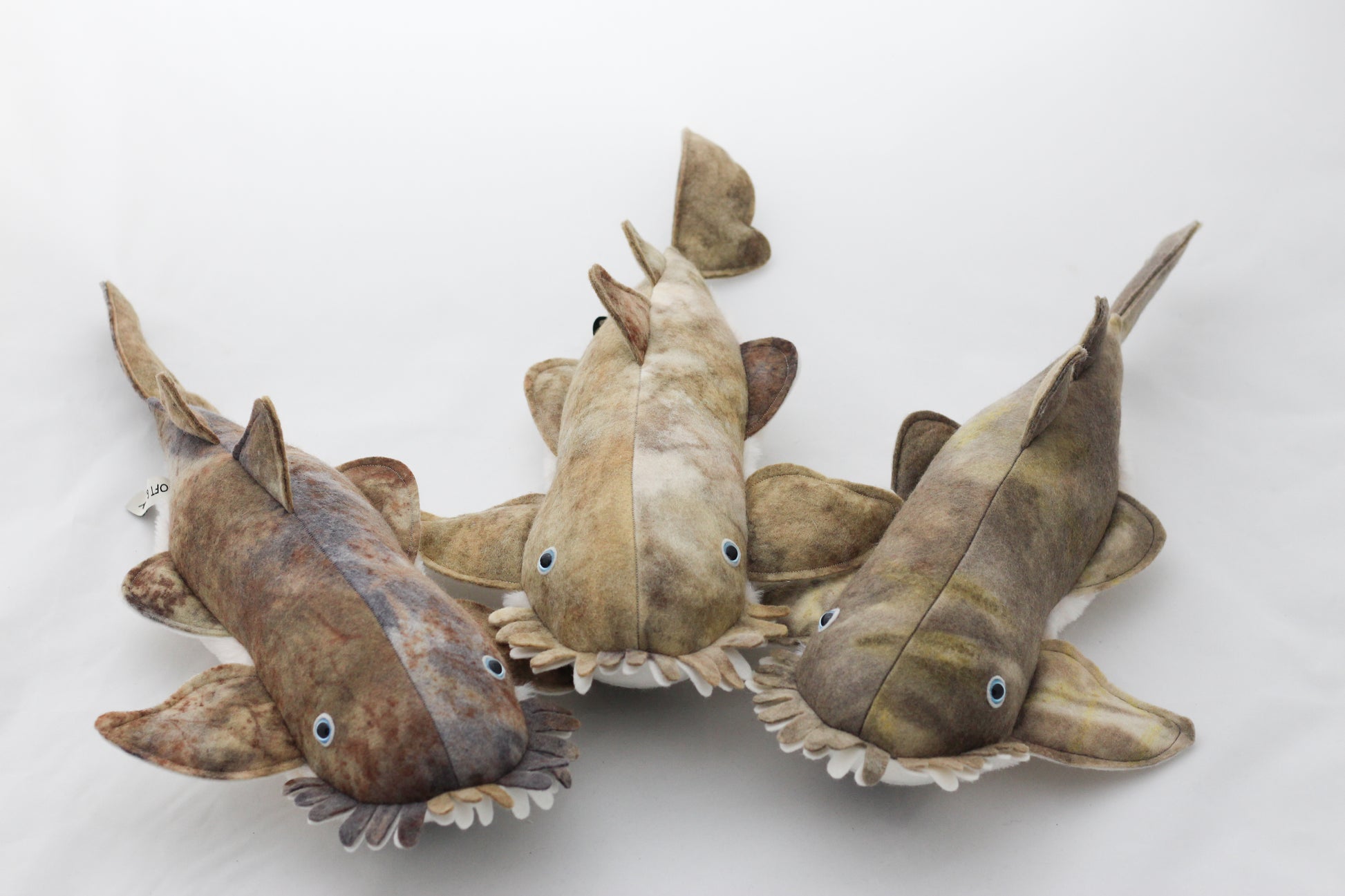 Three stuffed toy sharks on a white background