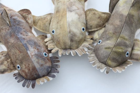 Three stuffed toy sharks on a white background