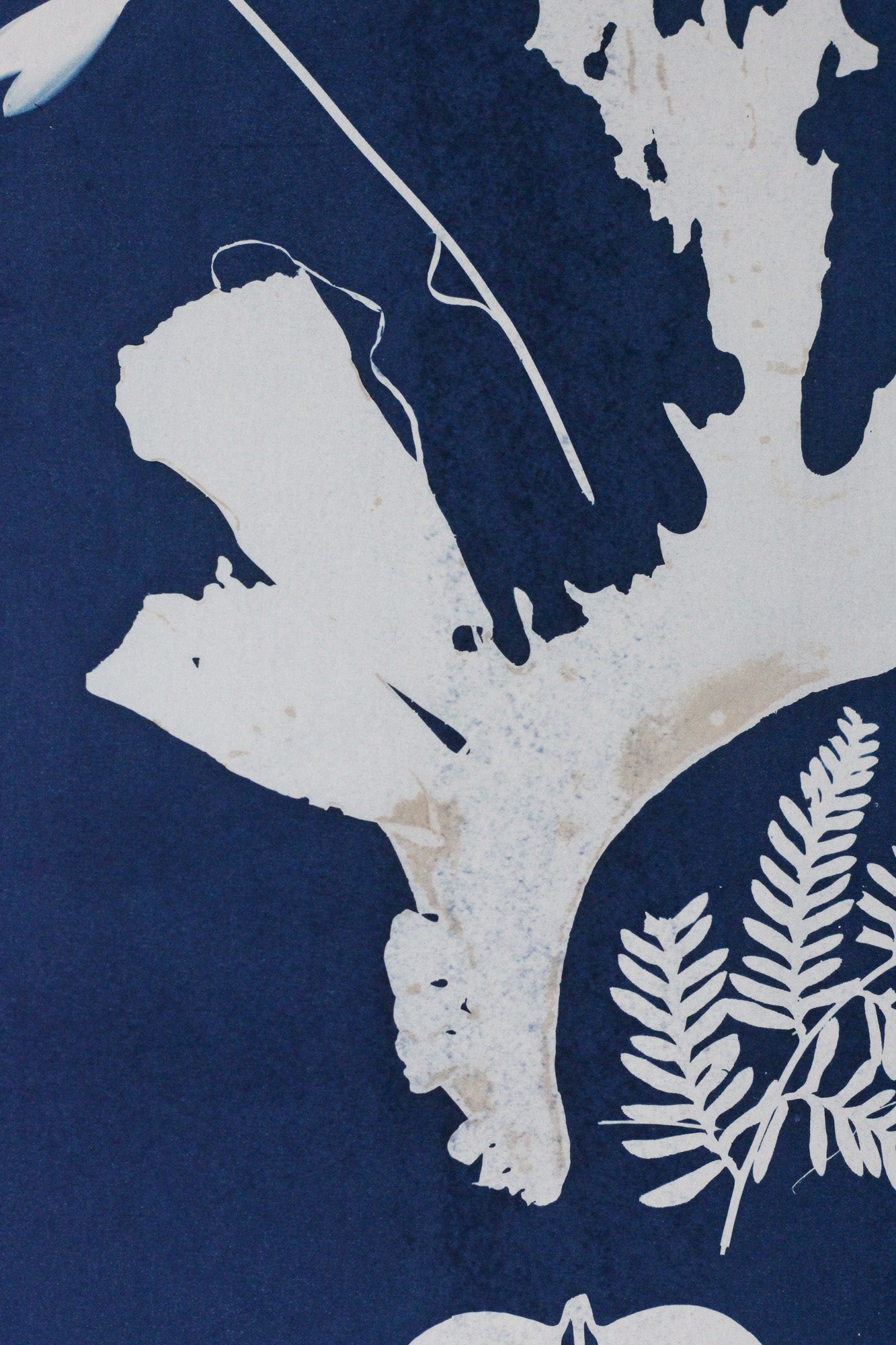 A close-up of a navy blue and off-white botanical pattern with leaf and branch motifs, showing a textured surface.