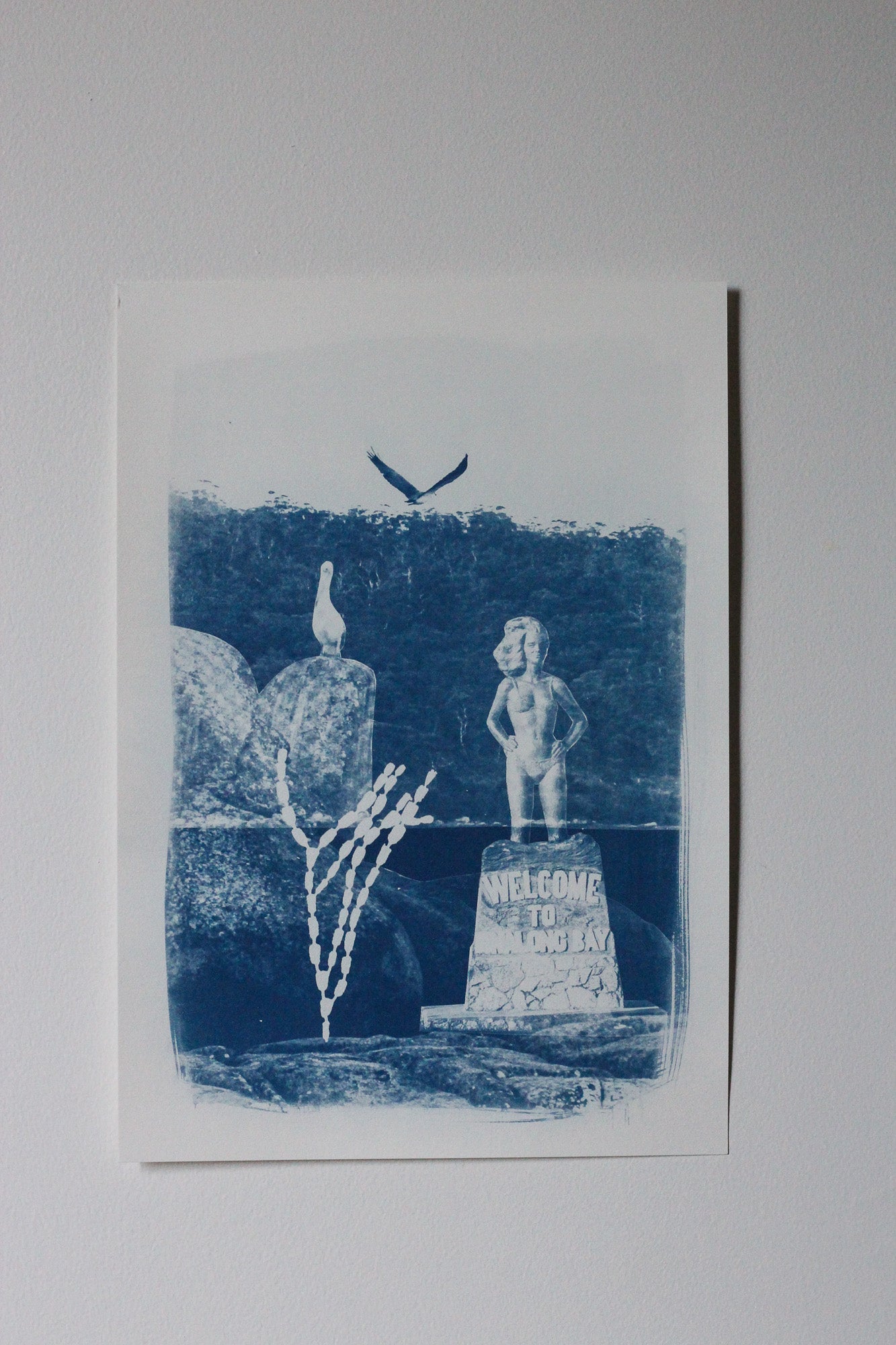 A blue and white cyanotype print artwork featuring a pelican, a sea eagle, and the Syrena of Binalong Bay statue overlooking Humbug point.