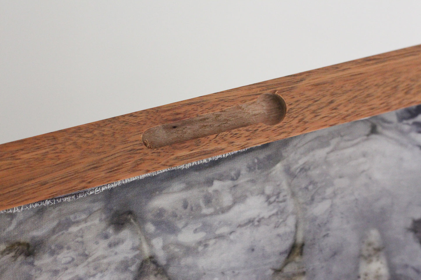 Close-up of a medium brown wooden hanging frame. 